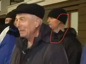 Passants souriants filmés à Marioupol, un jeune homme entouré en rouge derrière eux