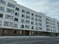 Immeubles neufs blancs et rue déserte dans Marioupol reconstruite
