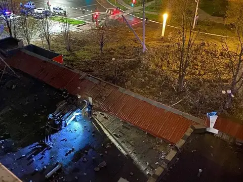 Cratère et voiture retournée dans une rue de Belgorod, la nuit