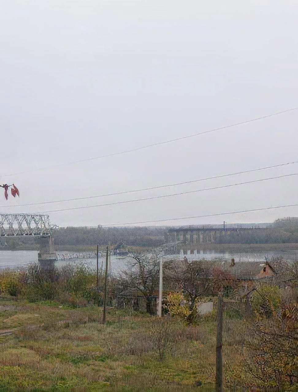 Le pont ferroviaire détruit d’Antonivka enjambant le Dnipro dans la brume