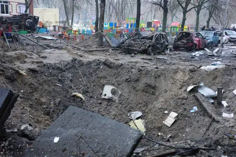Cratère de missile devant une aire de jeux, voitures calcinées, Kyiv